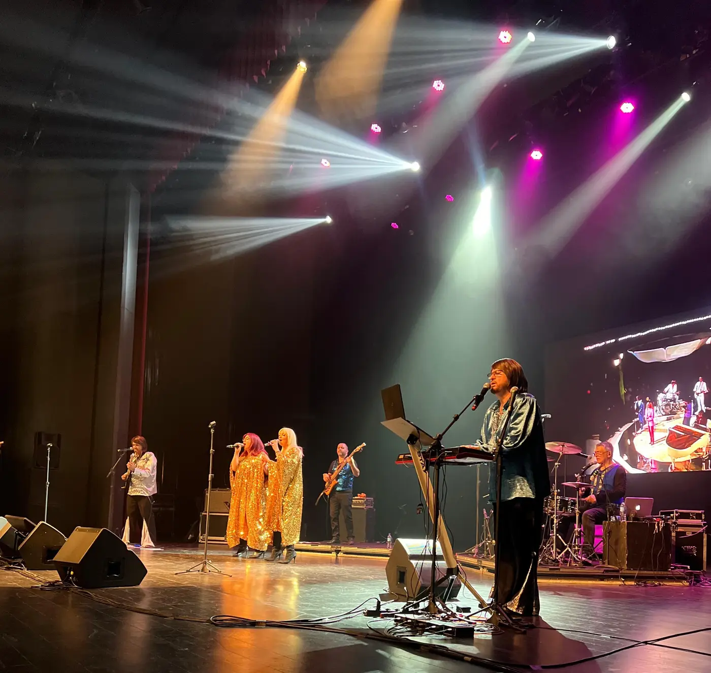 ABBA Alive no palco sob o telão com o logo da banda